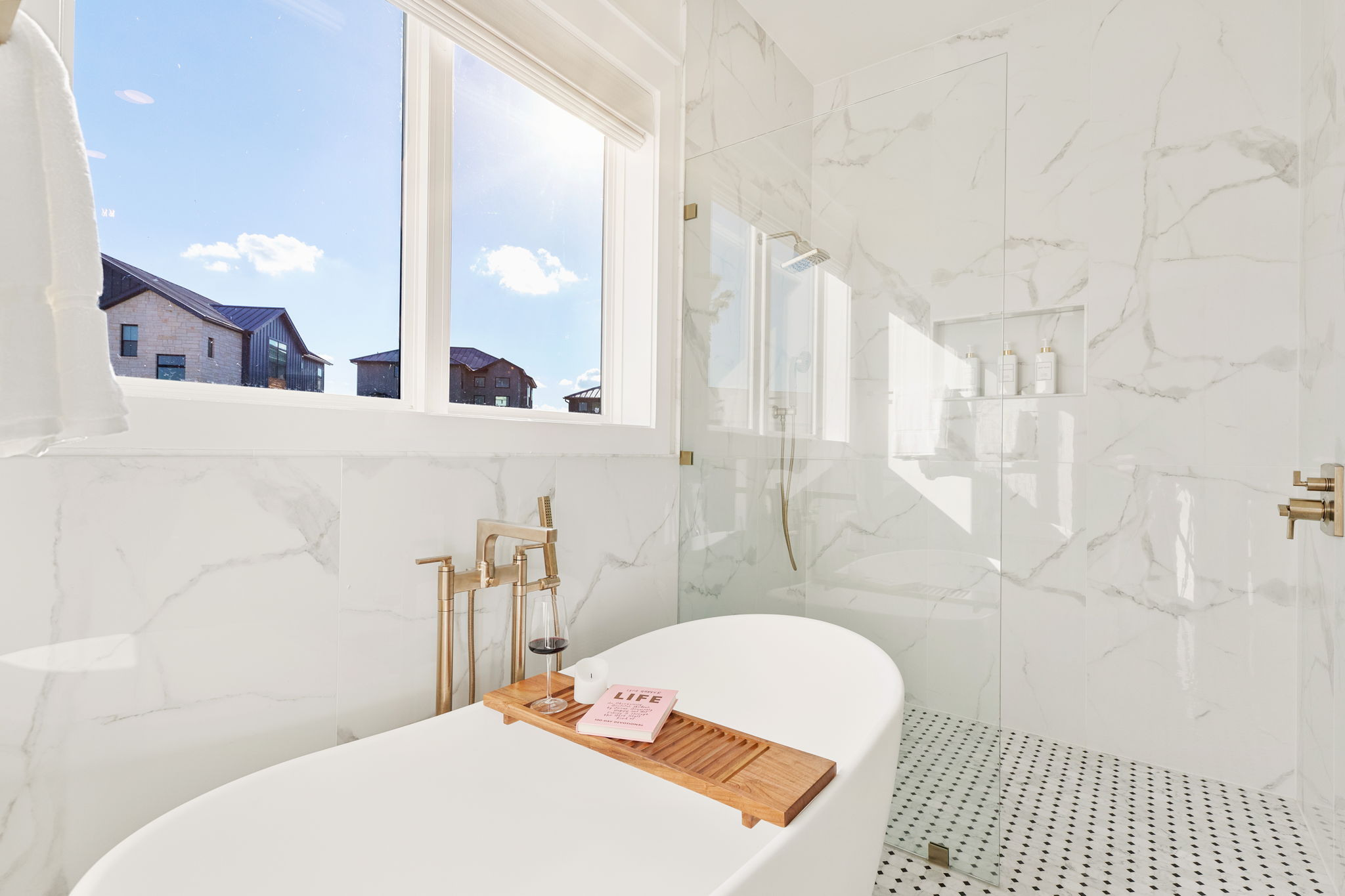 Primary bath with soaking tub and marble shower styled by Pam Melson