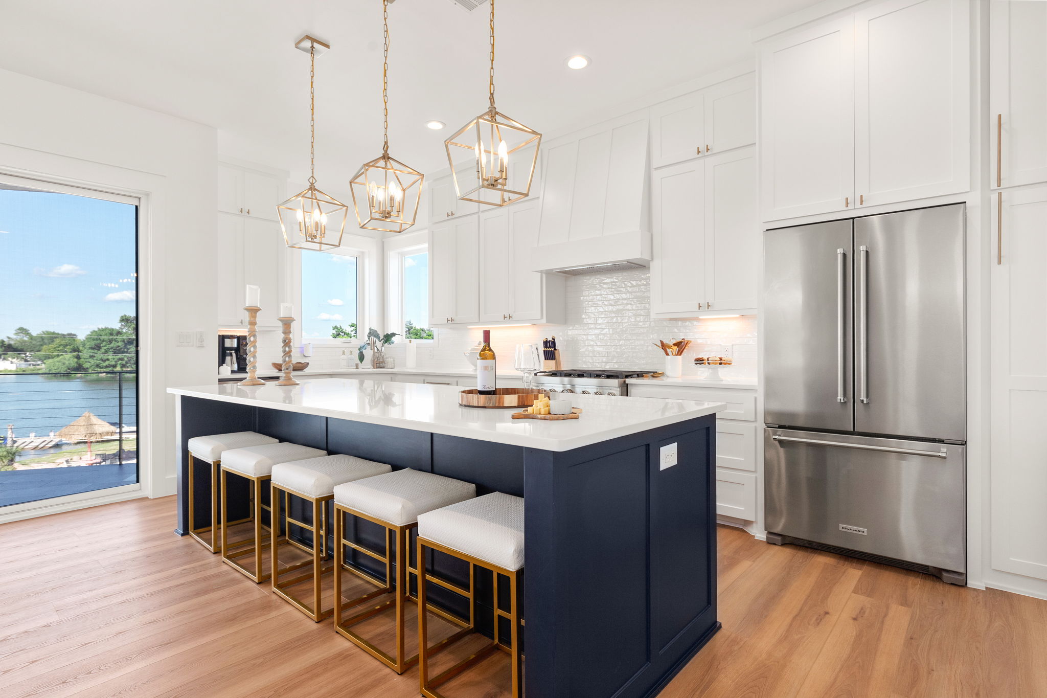 Kitchen with navy island and brass pendants styled by Pam Melson
